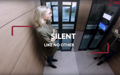 LSM Mobility Intérieur d'un homelift électrique silencieux avec une femme blonde souriante. Le texte "SILENT LIKE NO OTHER" est superposé sur l'image.