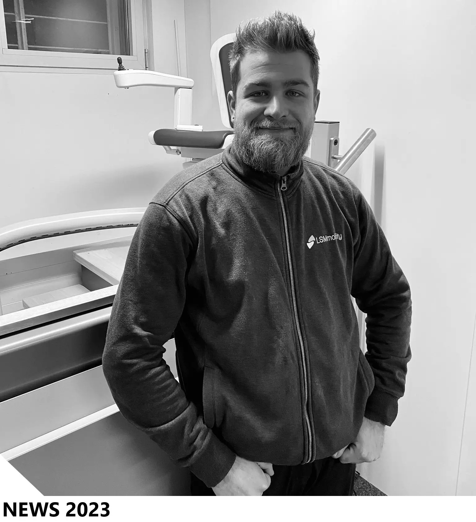 LSM Mobility Un homme souriant, portant une veste LSMmobility, se tient devant un équipement médical. Nouvelles 2023 LSMmobility.