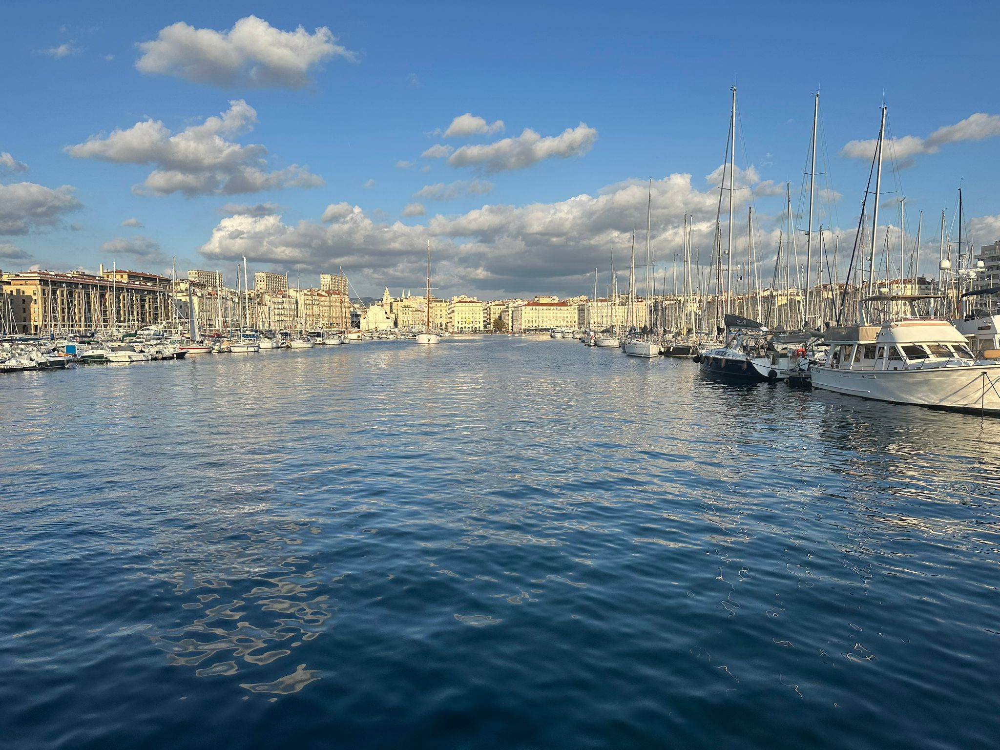 LSM Mobility Vue du Vieux-Port de Marseille, avec ses nombreux bateaux et voiliers amarrés. Ciel bleu et nuageux, idéal pour un séminaire à Marseille.
